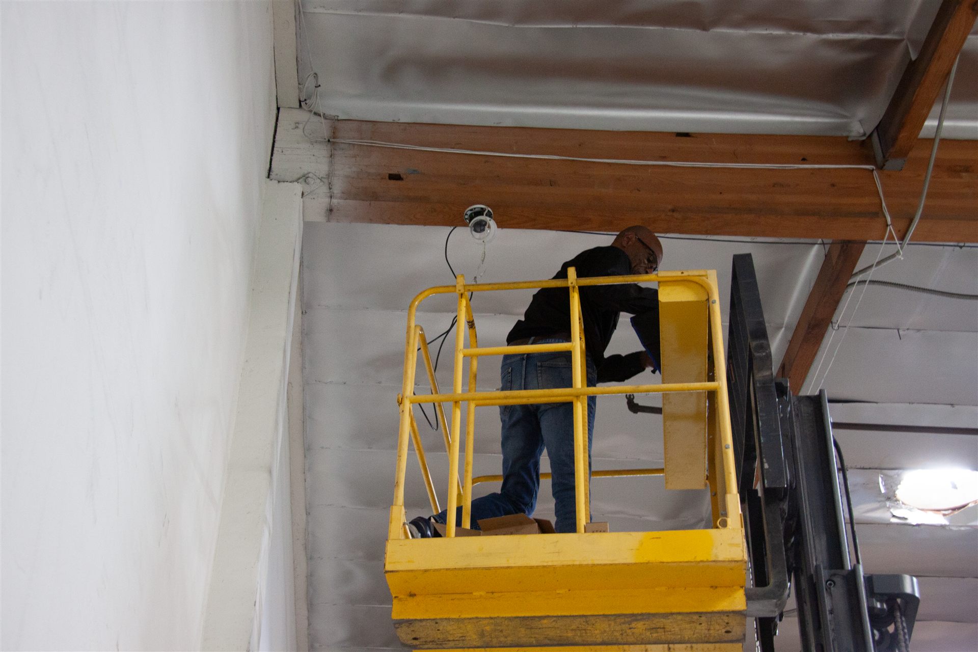 OSSUM IT technician installing a security camera on-site